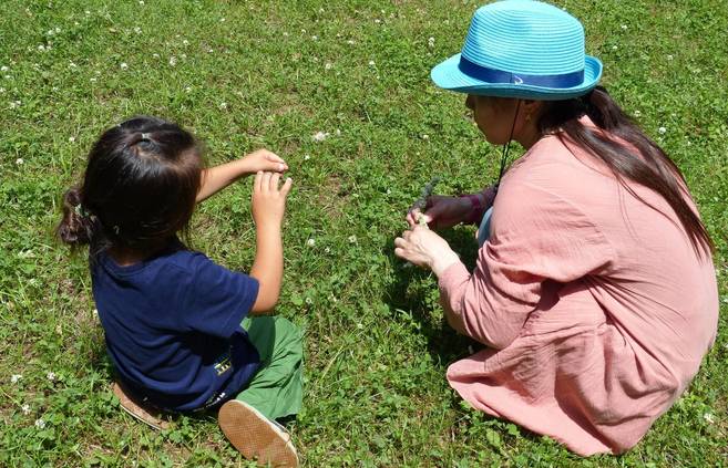絵本の読み聞かせと自然遊びの写真