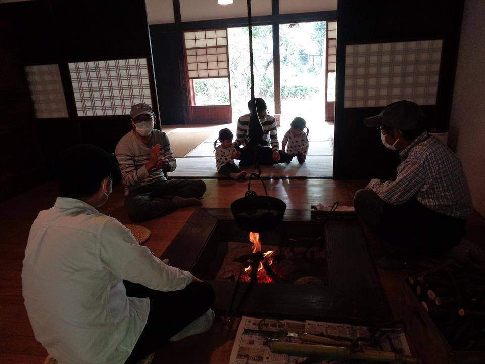 古民家主屋の囲炉裏で火を焚いています。の写真