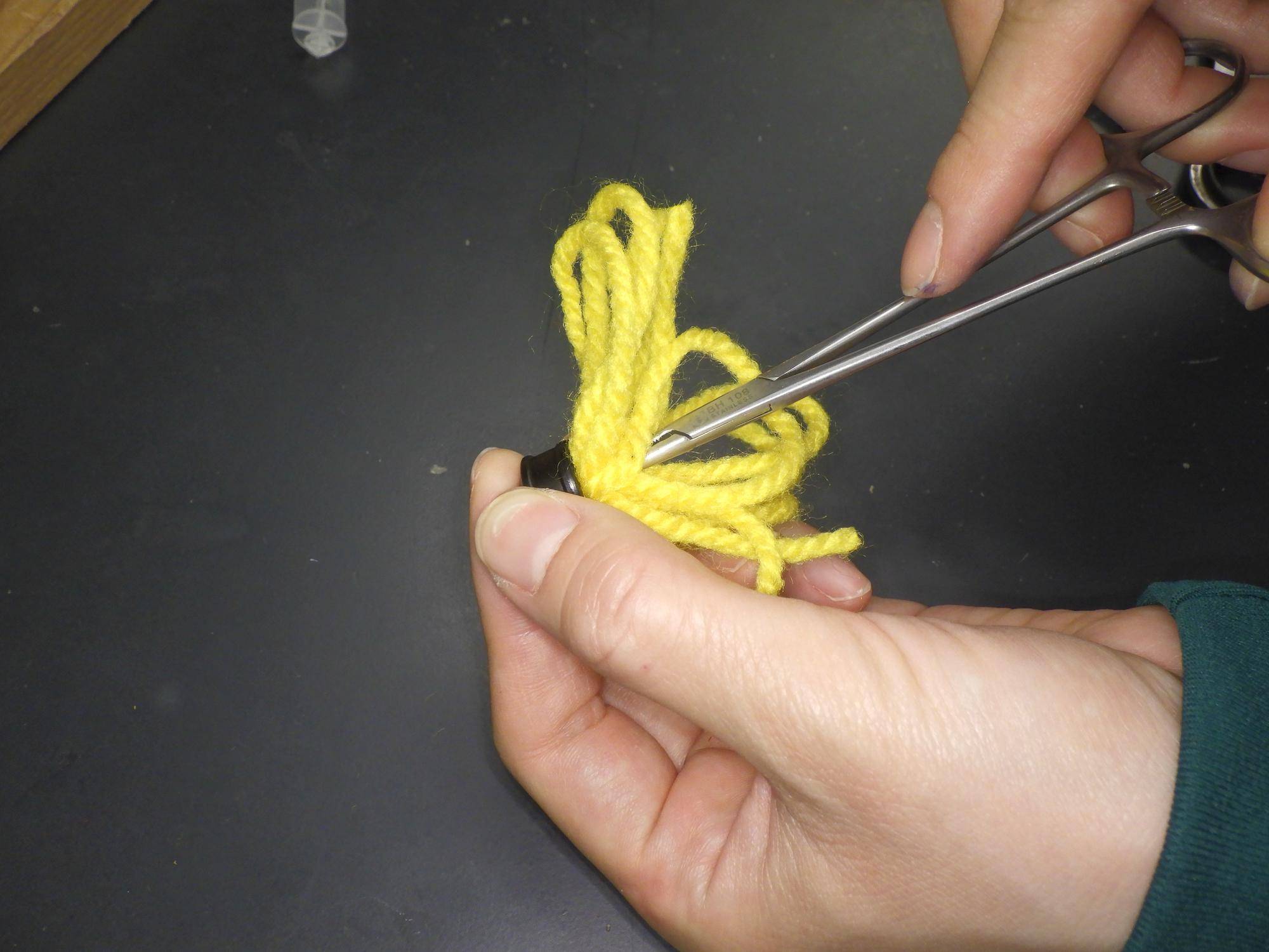 毛糸の束をゴムの穴に押し込んでいるところ.jpg