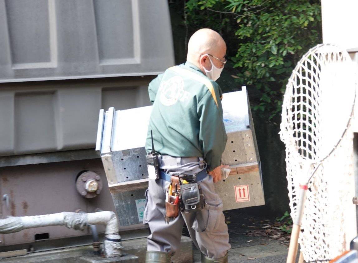 スマイラーを入れる予定の輸送箱を運ぶ担当者